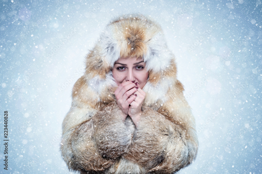 Frozen young woman in a fox fur coat warming hands, cold, snow, frost,  blizzard Stock Photo | Adobe Stock