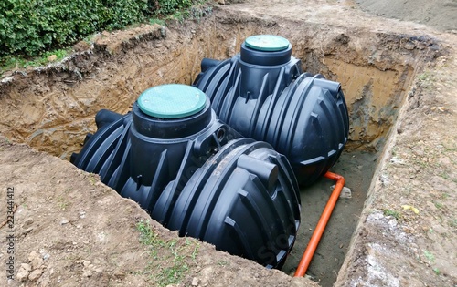 Two plastic underground storage tanks placed below ground for harvesting rainwater. The underground water septic tanks, for use as ecological recycling rainwater. Tank for home water harvest. photo