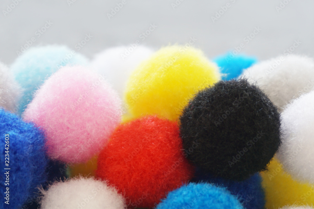 Multicolor pom pom balls close up on the gray background