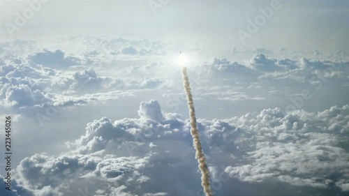Rocket launching through the clouds and into space photo