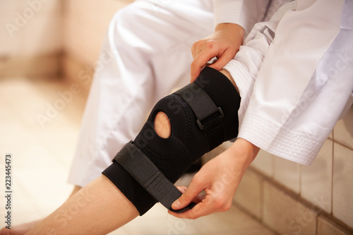 leg with one knee in a protective knee brace