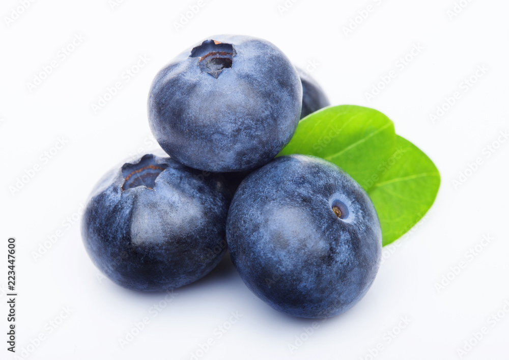 Fresh raw organic blueberries with leaf on white background. Macro close up Fresh raw organic blueberries with leaf on white background. Macro close up