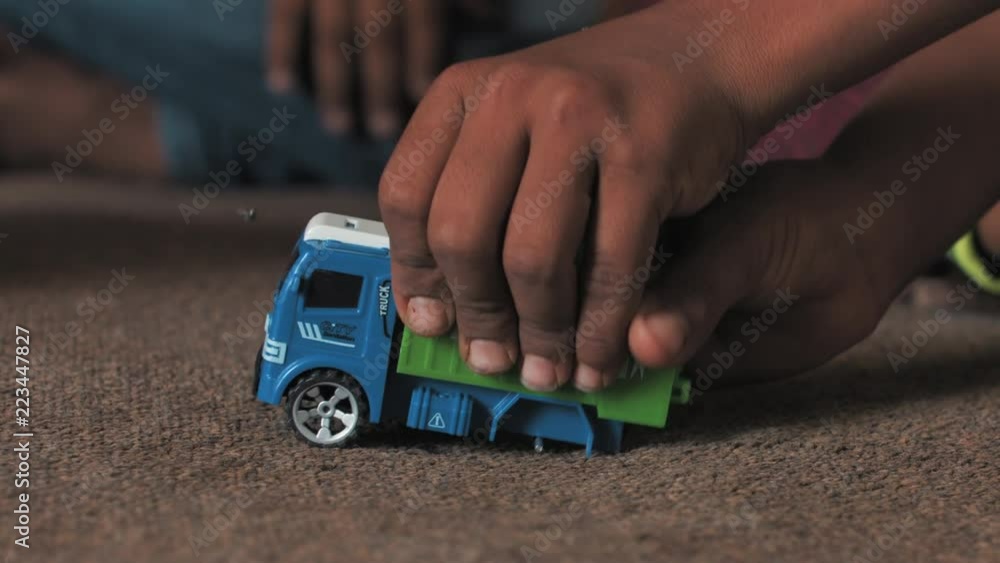 Refugee child plays with a Broken car toy, Poor Boy Plays with a broken