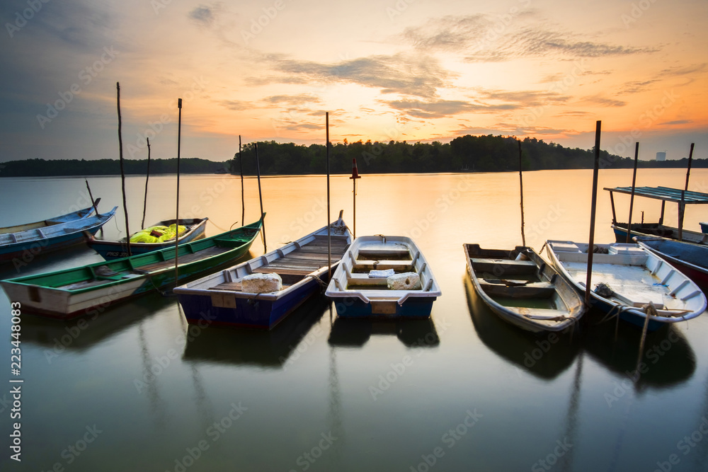 resting boat at boat pier lumut,Malaysia during beautiful sunrise. soft focus,blur due to long exposure. visible noise due to high ISO.