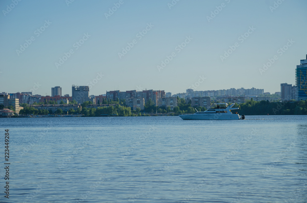 Boat on the river Dnieper and buildings on the opposite bank