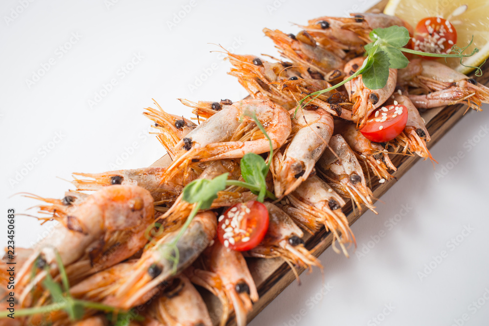 Lots of shrimps on the wooden board with lemon Lots of shrimps on the wooden board with lemon