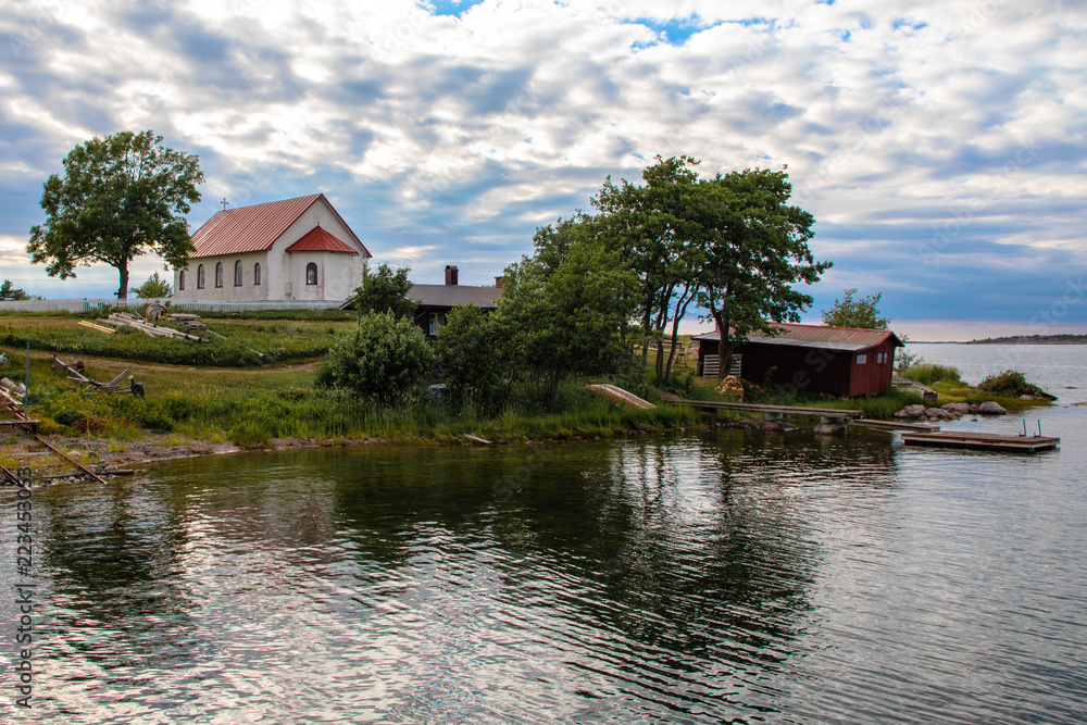 Looking west towards the church on the Island of Aspö in Archipelago National Park (Skärgårdshavet nationalpark), Finland, in the Baltic Sea, early on a cloudy evening during midsummer. Looking west towards the church on the Island of Aspö in Archipelago National Park (Skärgårdshavet nationalpark), Finland, in the Baltic Sea, early on a cloudy evening during midsummer.