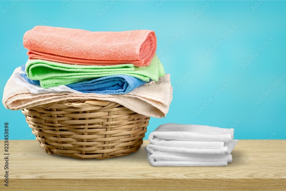Laundry Basket with colorful towels on background
