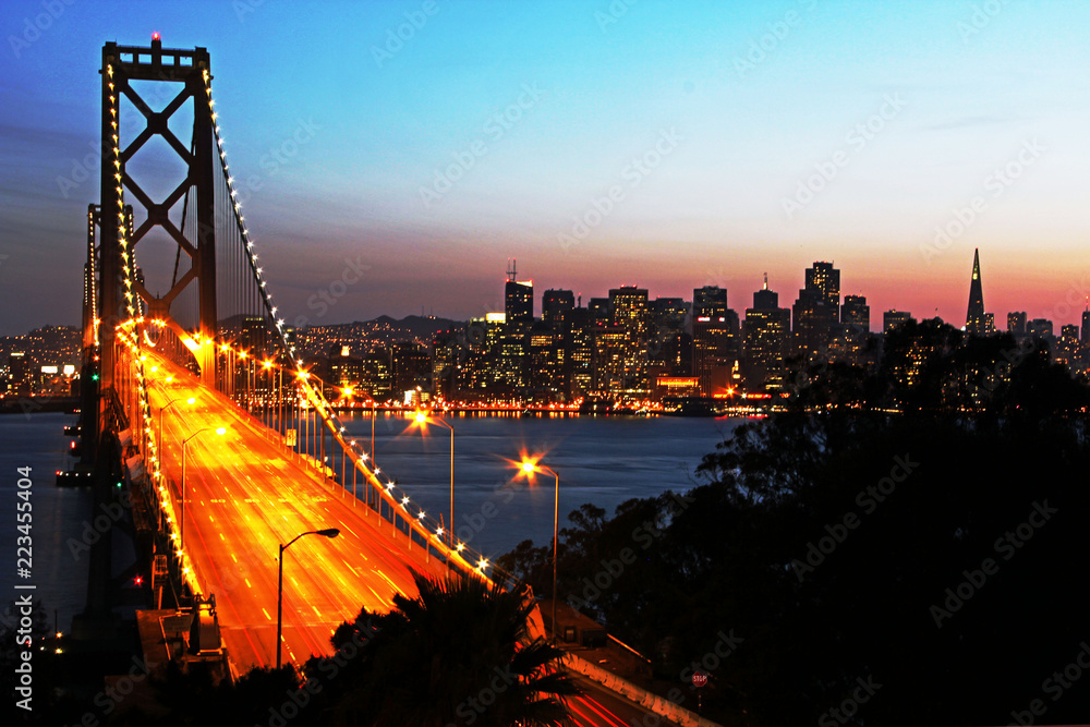San Francisco Bay Bridge at sunset from Treasure Island - shows traffic and city lights