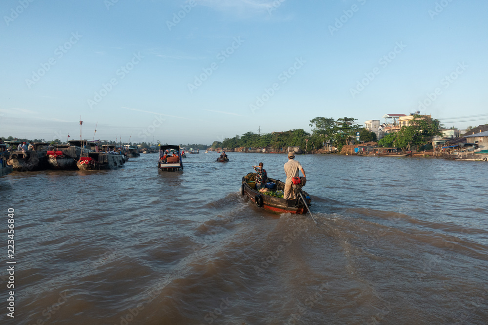 Obraz premium Traffic and transport on floating market by vessel, boat, ship in Cai Rang floating market at Mekong River. Royalty free stock image of the floating market or river market in Can Tho, Vietnam