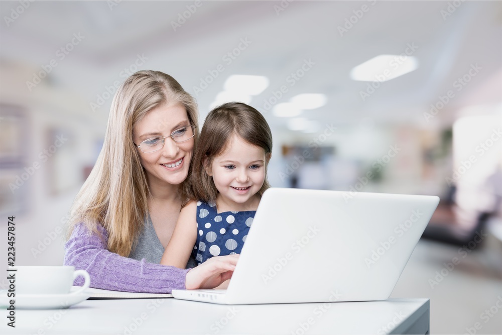 Mother and daughter using laptop at home Mother and daughter using laptop at home