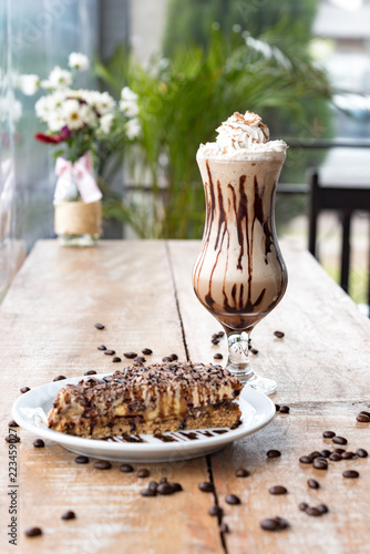 Iced Coffee with chocolate pie flowers at wooden table