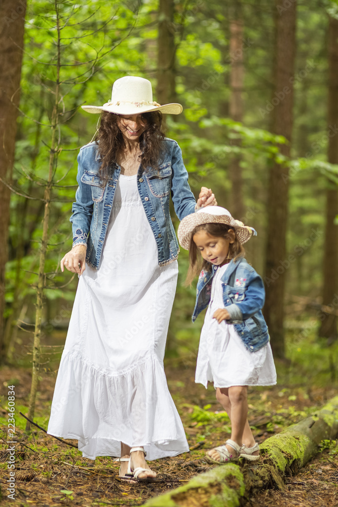 Portrait of Young Caucasian Mother with Her Daughter Playing Together in Green Summer Forest Outdoors.