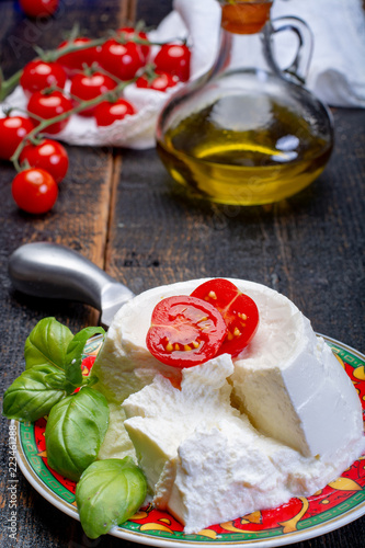 Italian soft cheese, young white ricotta cheese served with fresh basil and tasty ripe cherry tomatoes