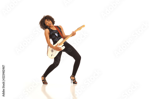 Millennial female musician playing electric guitar isolated on white backdrop