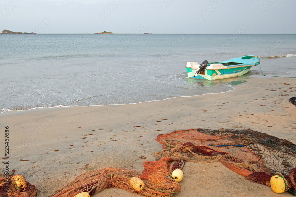 Small fishing boat and fishing nets on Nilaveli beach in Sri Lanka Asia  Stock Photo
