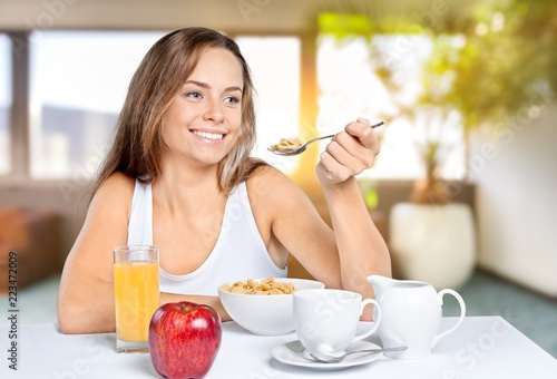 Attracive young woman enjoying tea and fruits