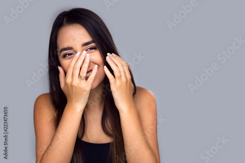 Adorable fun cute shy bashful hispanic female laughing, playful, isolated, covering face