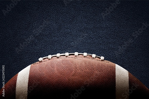 American football ball on black background illuminated