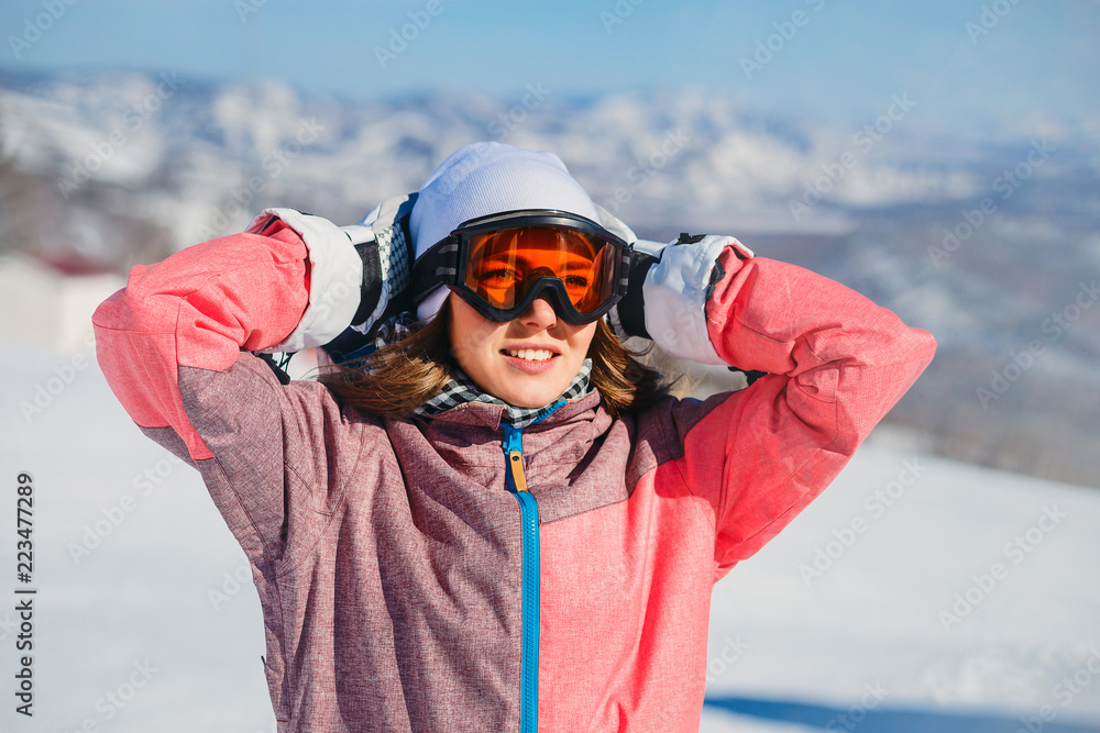 the young skier to ski goggles in the mountains in winter