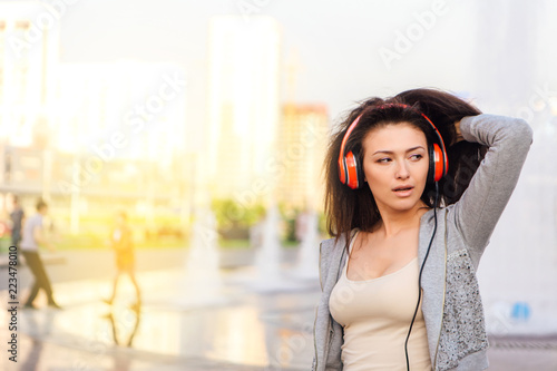 Young woman listening to music streaming with headphones.