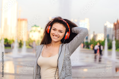 Young woman listening to music streaming with headphones.