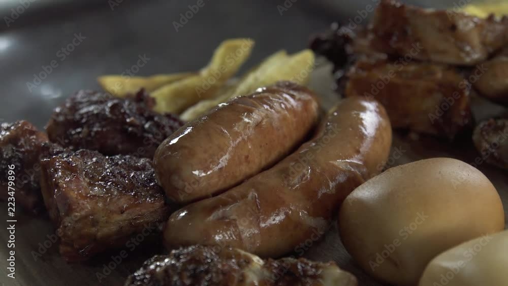 Meat, pork ribs and sausages barbecue close up. Fried meat and grilled sausages. Appetizing picnic food and bbq. Meat, pork ribs and sausages barbecue close up. Fried meat and grilled sausages. Appetizing picnic food and bbq.
