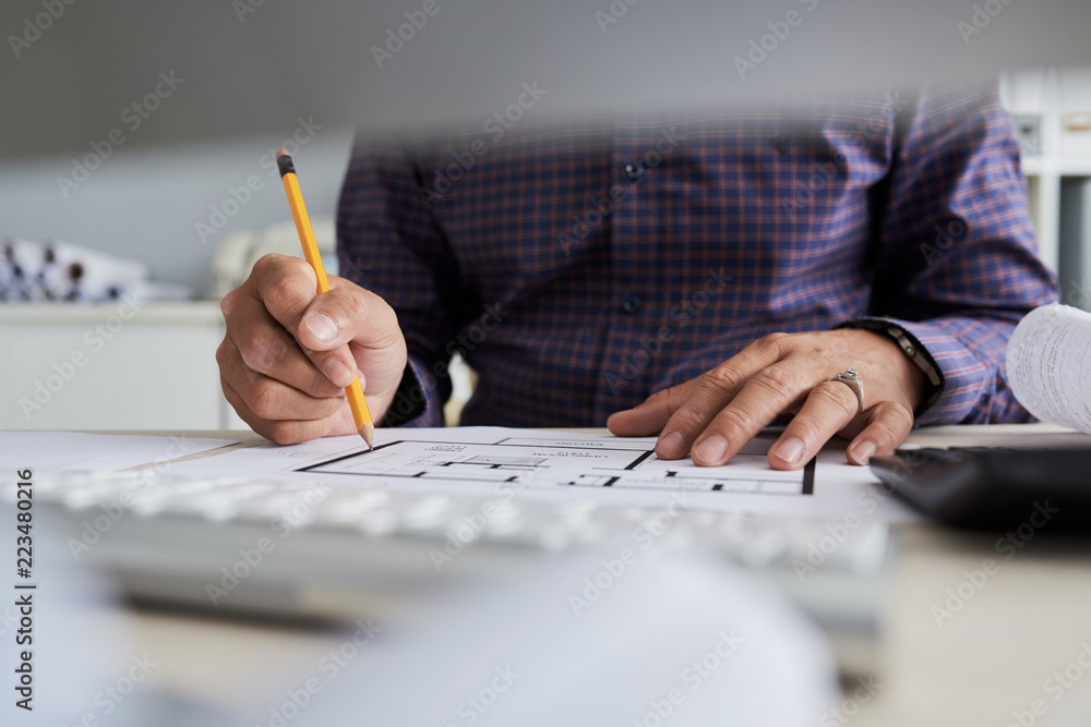 Fotografie Architect checking construction project at his workplace in office