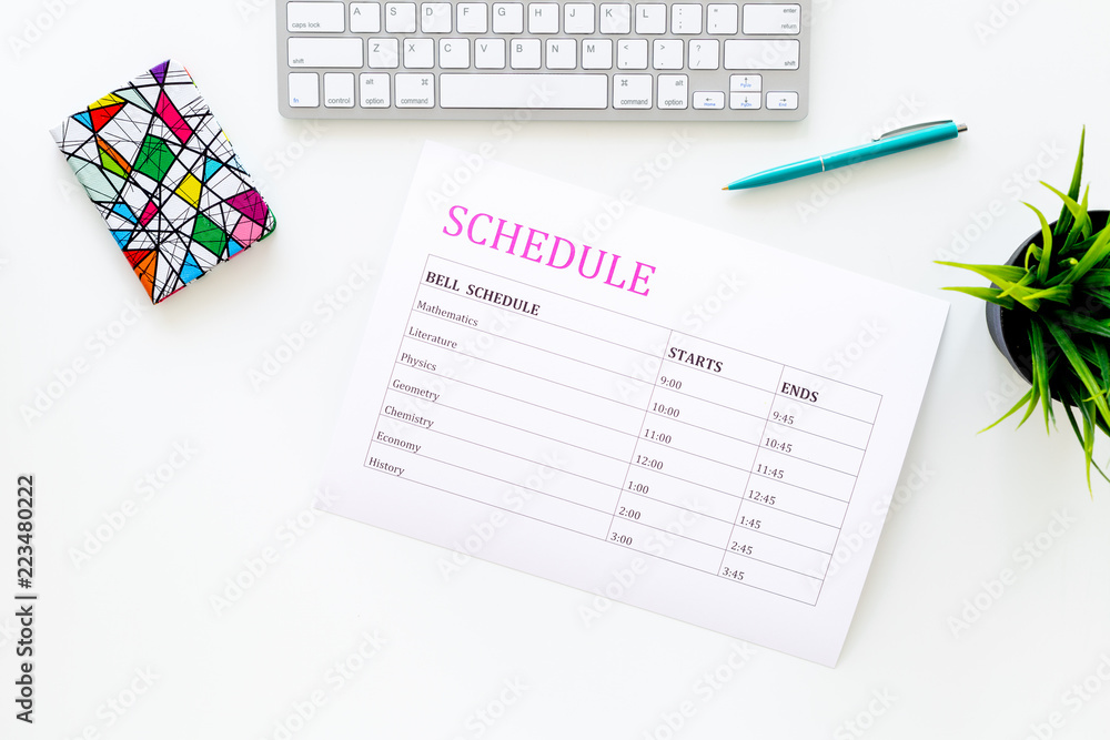 School student's schedule with time of lessons on white office desk with computer keyboard top view copy space School student's schedule with time of lessons on white office desk with computer keyboard top view copy space