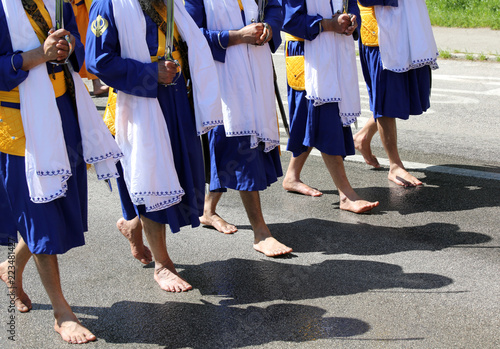sikh men without shoes on the road during a religious celebratio