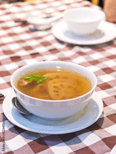 Chinese Lotus Root soup in a white bowl on red checked Pattern tablecloth