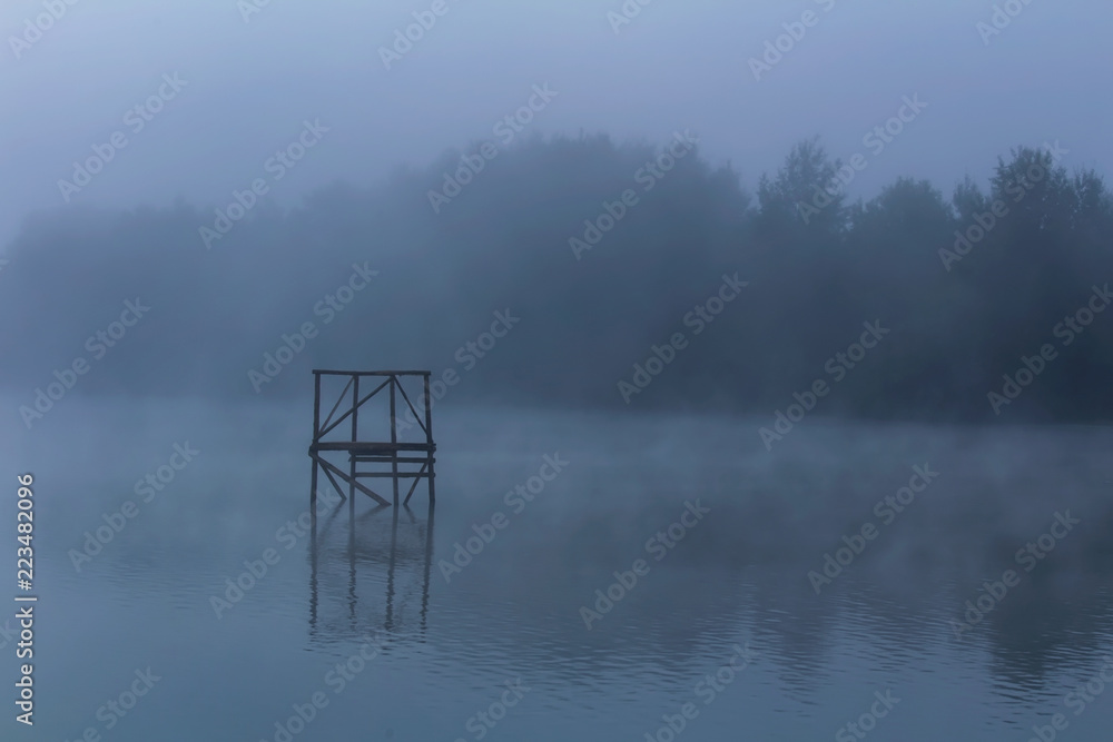 Silhouette of wood construction in pond