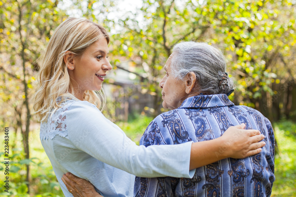 Fototapeta premium Embracing old lady outdoor