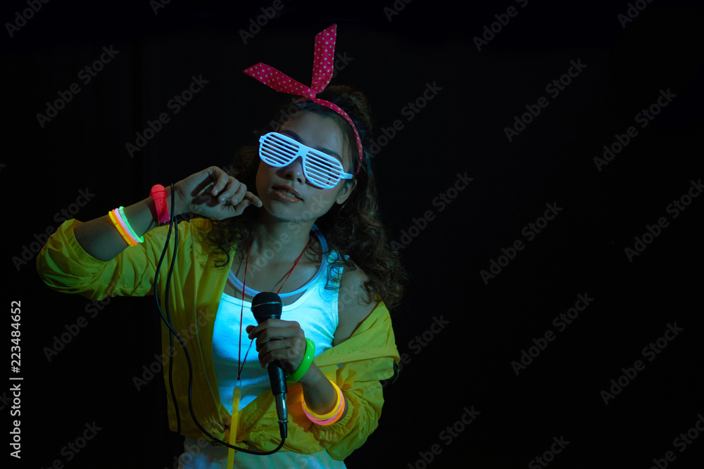 Female hip-hop singer dancing under UV light Stock Photo | Adobe Stock