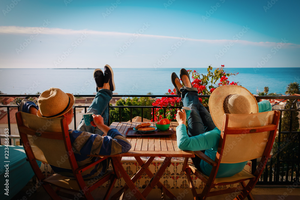 young couple have breakfast on balcony terrace with sea view - obrazy, fototapety, plakaty 