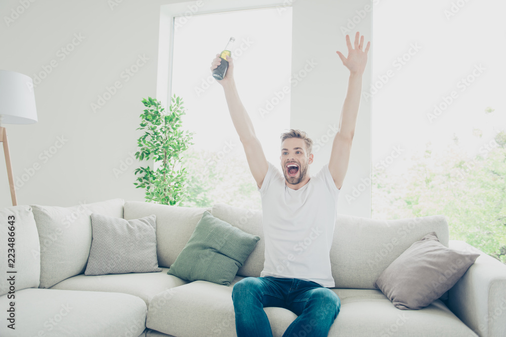 Photo of attractive, sporty man in jeans and white t-shirt sit o Photo of attractive, sporty man in jeans and white t-shirt sit o