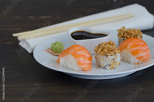 Sushi salmon witn wasabi, ginger  and chopsticks on black background . Japanese food concept. Copy space