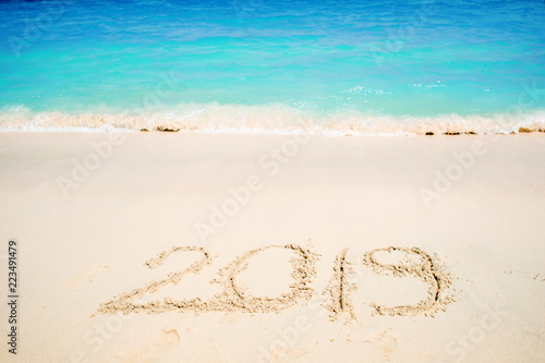 Inscription on the sand, celebrate the new year in the tropics. New year holidays