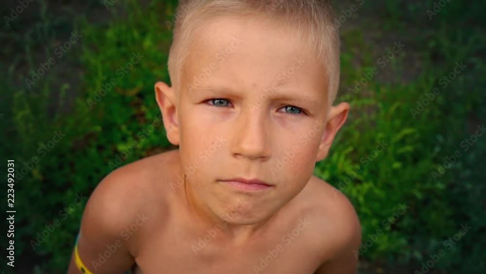 Close-up portrait of a blue-eyed little boy looking directly at the camera, a piercing look of a 6-year-old child, view from above Close-up portrait of a blue-eyed little boy looking directly at the camera, a piercing look of a 6-year-old child, view from above