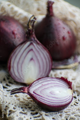 Red onion and red onion slices on wooden cutting board. Red onion.