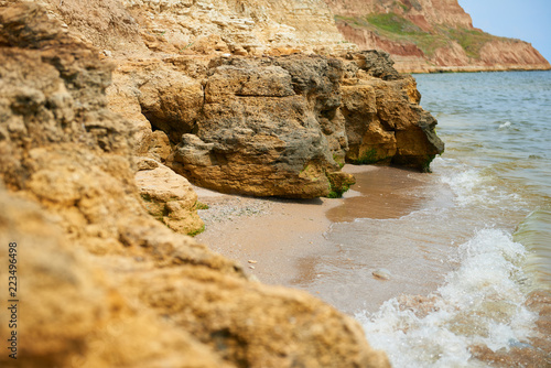 beautiful sea landscape, closeup of stone on the beach, sea coast with high hills, wild nature photo