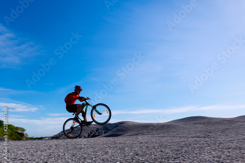 Fototapeta Naklejka Na Ścianę i Meble -  Cyclist riding mountain bike on the rocky trail at sunset.