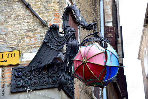 Venice - Sign with iron dragon holding colorful umbrellas