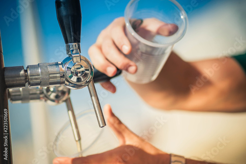 Hand of bartender pouring a beer in tap