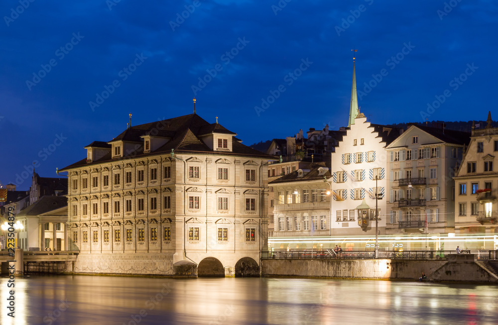 Beautiful cityscape of Zurich, Switzerland, with the Zürich Town Hall (Rathaus), seen from the shore of the river Limmat in the blue hour in summer