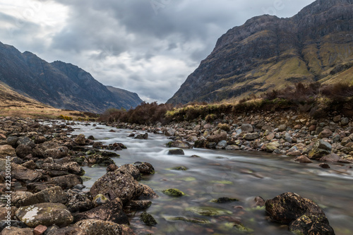 Glencoe river with smooth water flow and cloudy day. hill views at the back