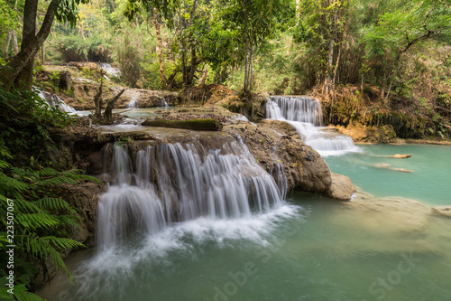 Beautiful view of several small cascades at the Tat Kuang Si Waterfalls near Luang Prabang in Laos on a sunny day.