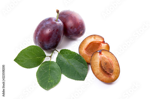 Group of whole and half of ripe plums with leaf isolated on a white background..