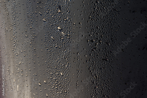 Droplets of dew on black polyurethane sheet that was photographed in the early morning Sun.