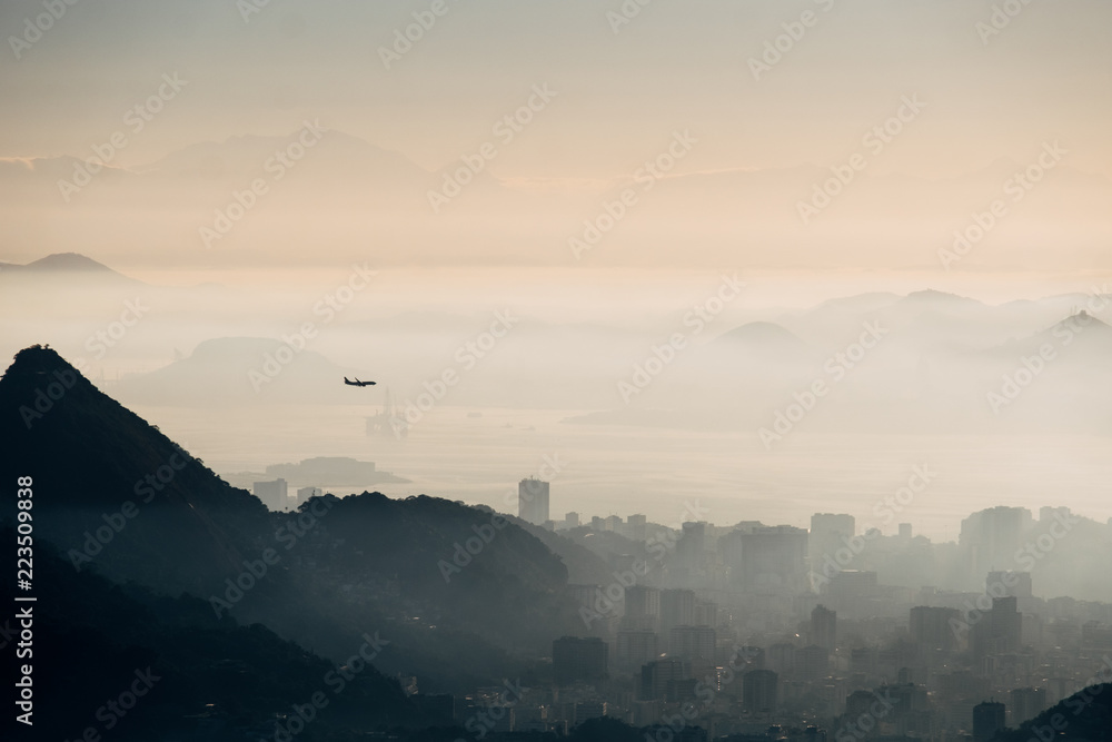 Brazil, Rio de Janeiro. Meeting the dawn on the hill Two brothers. View of the big city, lake, ocean, hills, mountains.  The plane flies over the city in the fog and over the mountains